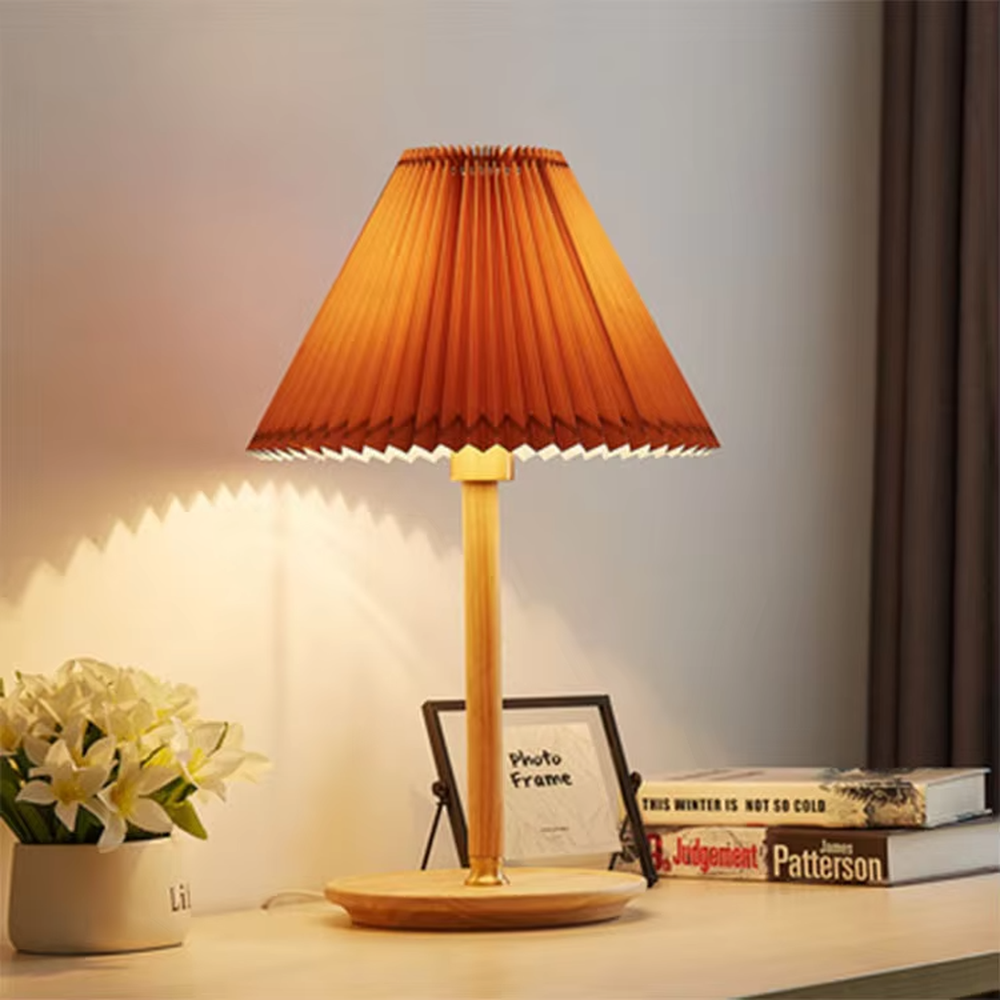 Nordic-style wooden pleated table lamp, with a light wood lamp pole and base paired with an orange pleated fabric lampshade, providing soft and warm light, designed to enhance the cozy atmosphere of spaces, suitable for bedroom nightstands, living room side tables, homestay guest rooms, etc.
