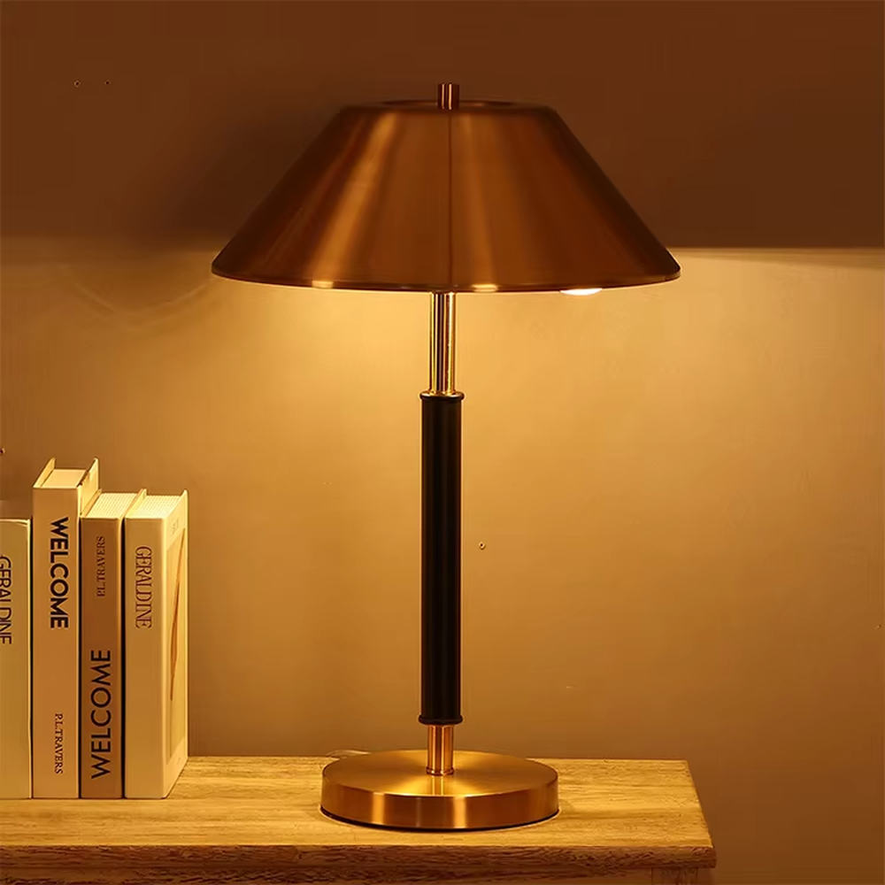 Light luxury gold-brown leather table lamp (gold metal lampshade + dark brown leather lamp post + metal base), warm light effect, creating a retro and high-end office and home atmosphere.