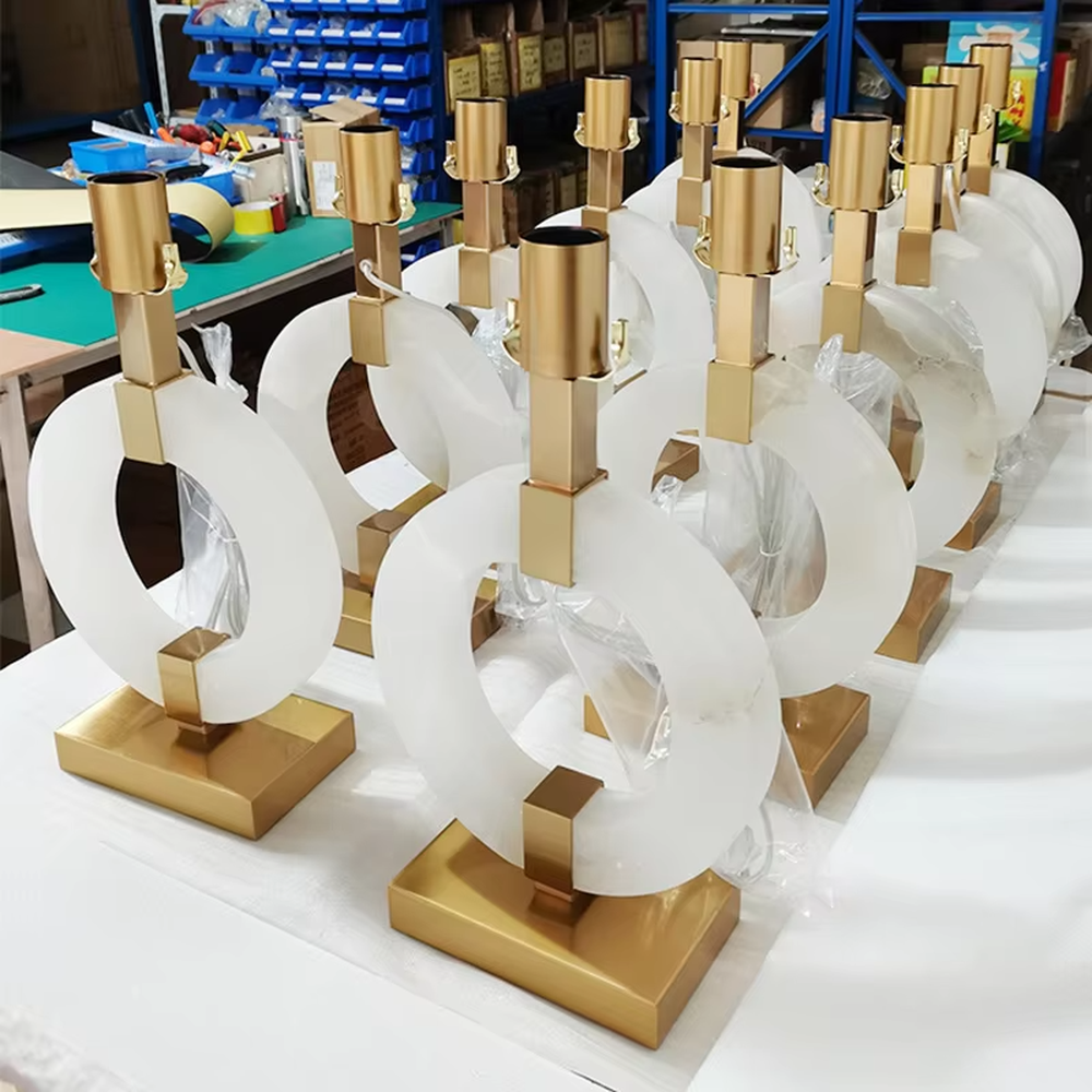 Light luxury white jade ring base table lamp, white jade-textured ring + golden metal decorations + white fabric lampshade, soft warm light, creating a light luxury elegant home atmosphere.