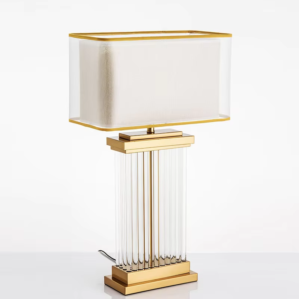 This light luxury modern table lamp features a gold metal frame, paired with a transparent crystal column lamp body and a double-layer square lampshade (inner fabric for soft light, outer transparent acrylic with gold trim). It serves both lighting and decorative purposes, ideal for bedroom bedside, living room side tables, hotel guest rooms and light luxury commercial spaces.