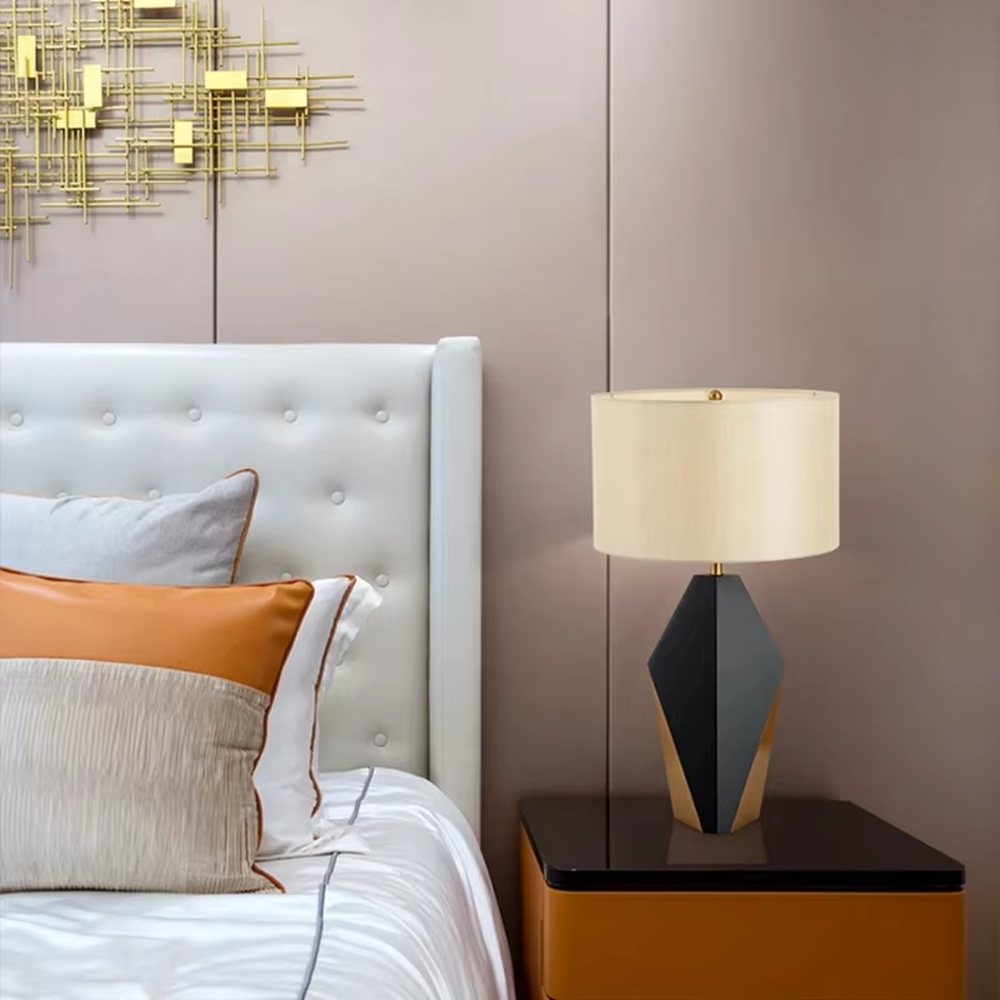Light luxury black-gold geometric diamond base table lamp, black geometric diamond base + golden decorative details + beige fabric lampshade, soft warm light, creating a high-end light luxury bedroom atmosphere.