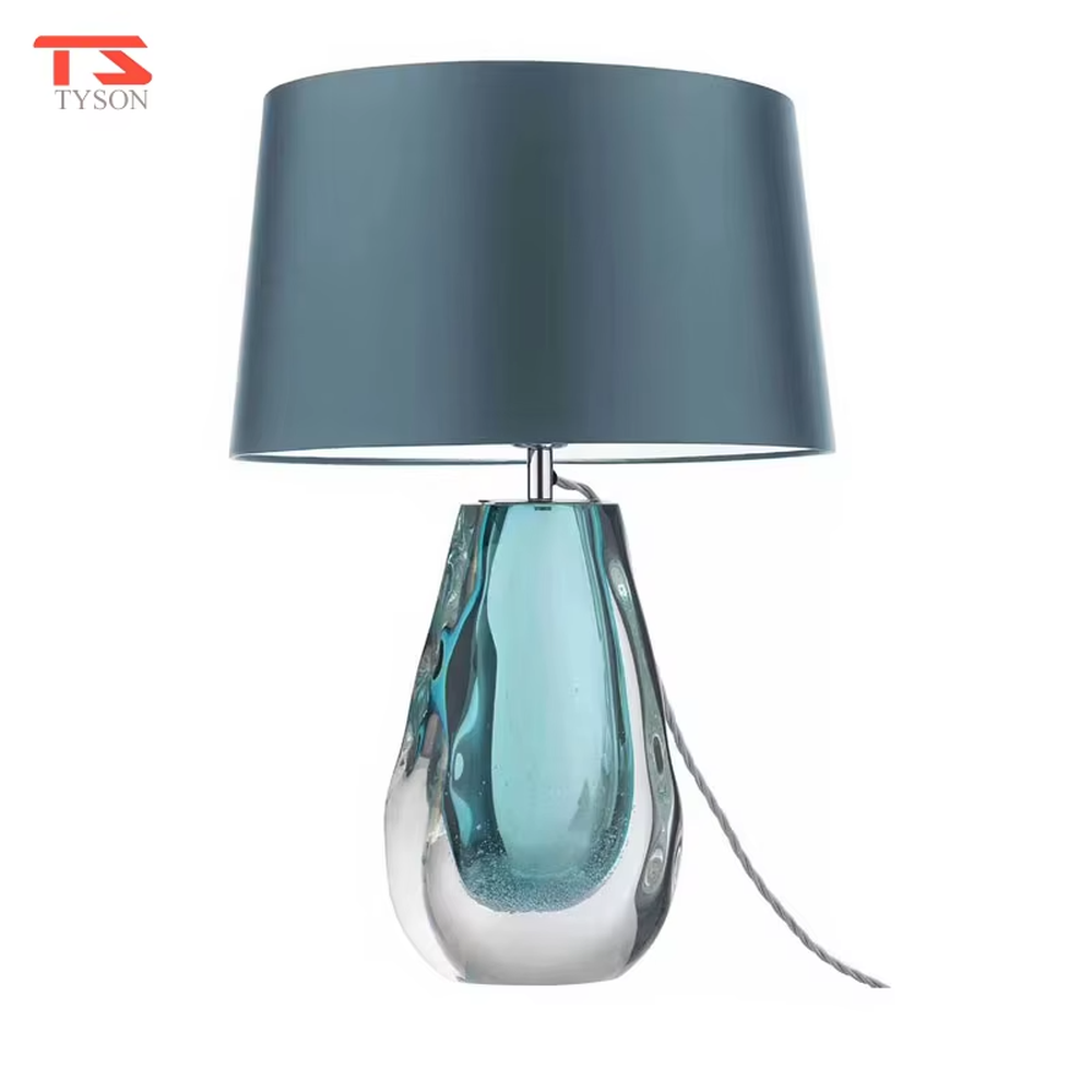 This is a fresh light luxury glass table lamp, with a royal blue fabric lampshade paired with a blue-green gradient hand-blown glass base, featuring both decorative and lighting functions, ideal for warm indoor scenarios such as bedroom nightstands and living room side tables.