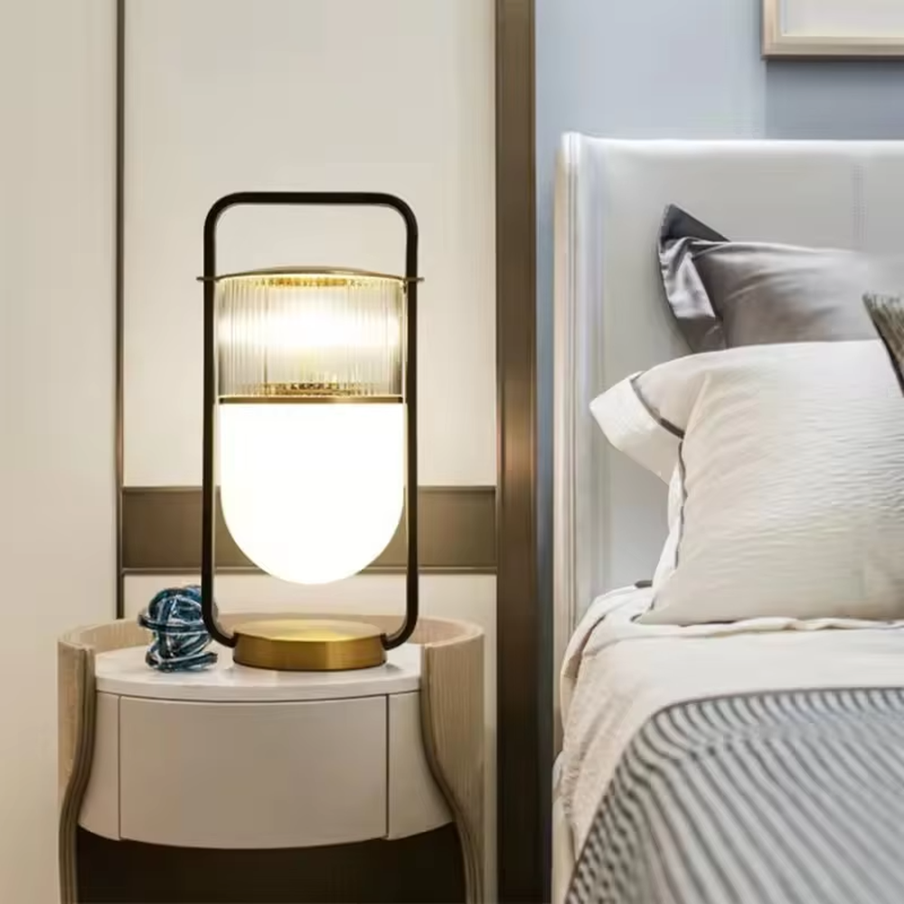 This modern light luxury lantern-shaped table lamp features a black-gold metal frame (with a handle design), paired with a double-layer lampshade of vertical-grain transparent glass and milk-white frosted glass, with an exquisite gold base. It serves both lighting and decorative purposes, ideal for light luxury spaces such as bedroom bedside tables, living room side tables, and hotel guest rooms.