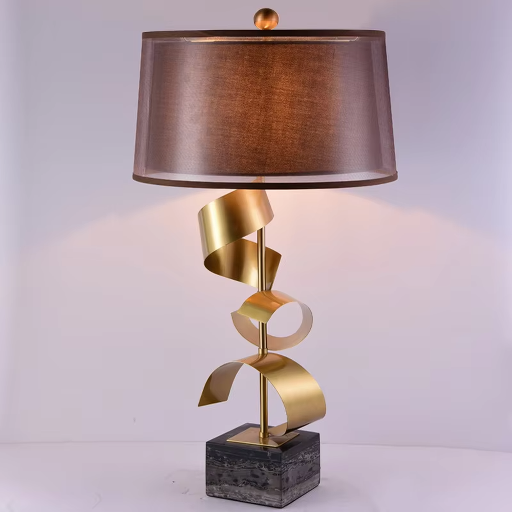 Light luxury spiral metal table lamp (gold spiral pole + pink-brown fabric shade), warm light effect, creating a dynamic and high-end warm space atmosphere.