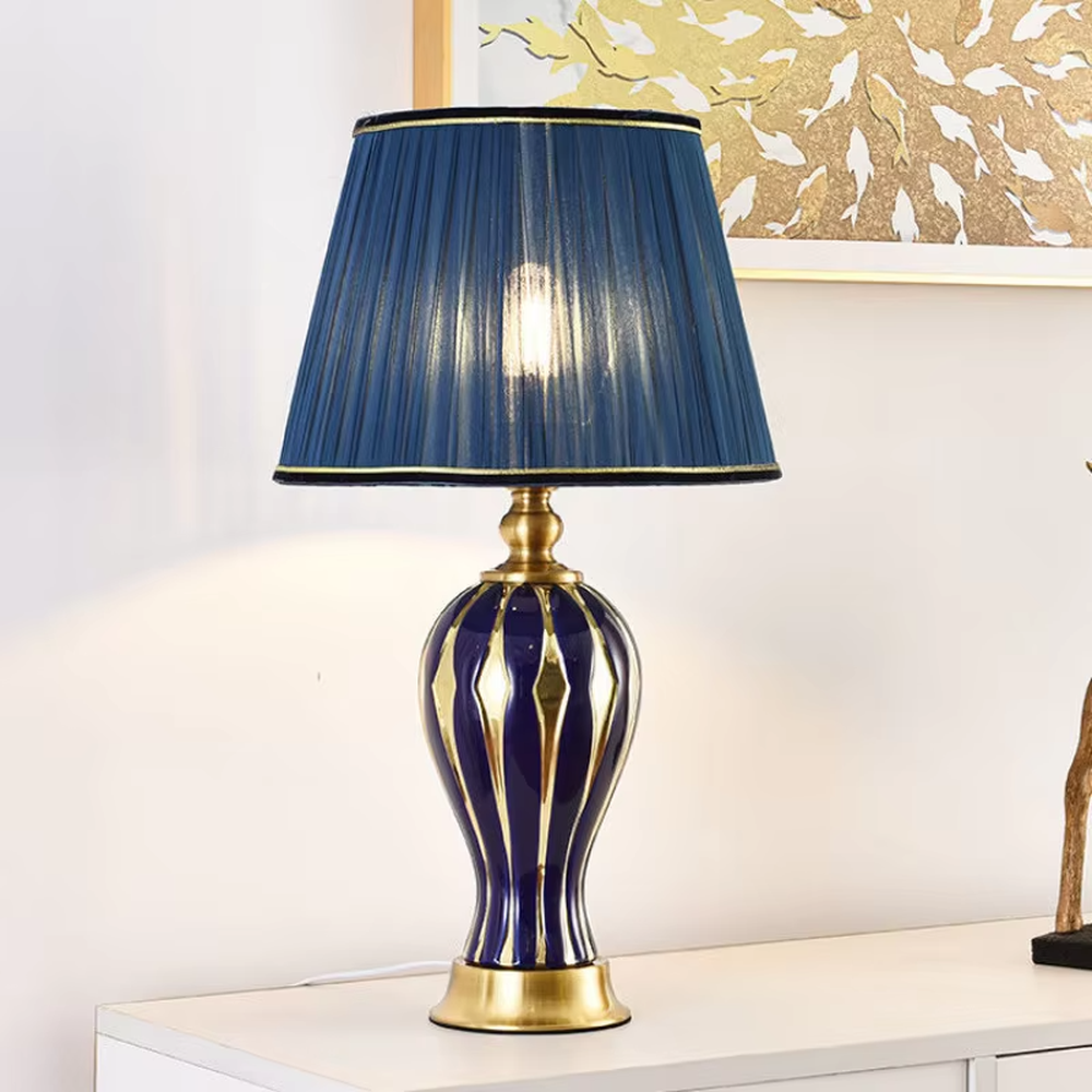 European-style light luxury ceramic table lamp, with a green-gold gradient wavy ceramic base, off-white pleated fabric lampshade and gold metal details, providing soft and warm light, designed to enhance the retro and elegant atmosphere of spaces, suitable for bedroom nightstands, living room side tables, European-style homes and hotel guest rooms, etc.