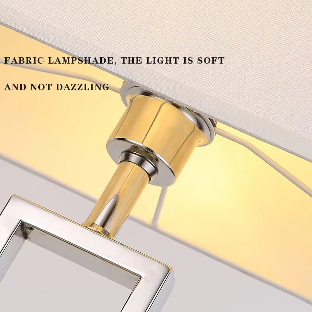 Modern minimalist table lamp with a chrome-plated metal frame and a rectangular off-white fabric lampshade, emitting soft and warm light. It is both decorative and practical, suitable for lighting and decoration in living rooms, bedrooms, studies and other spaces.