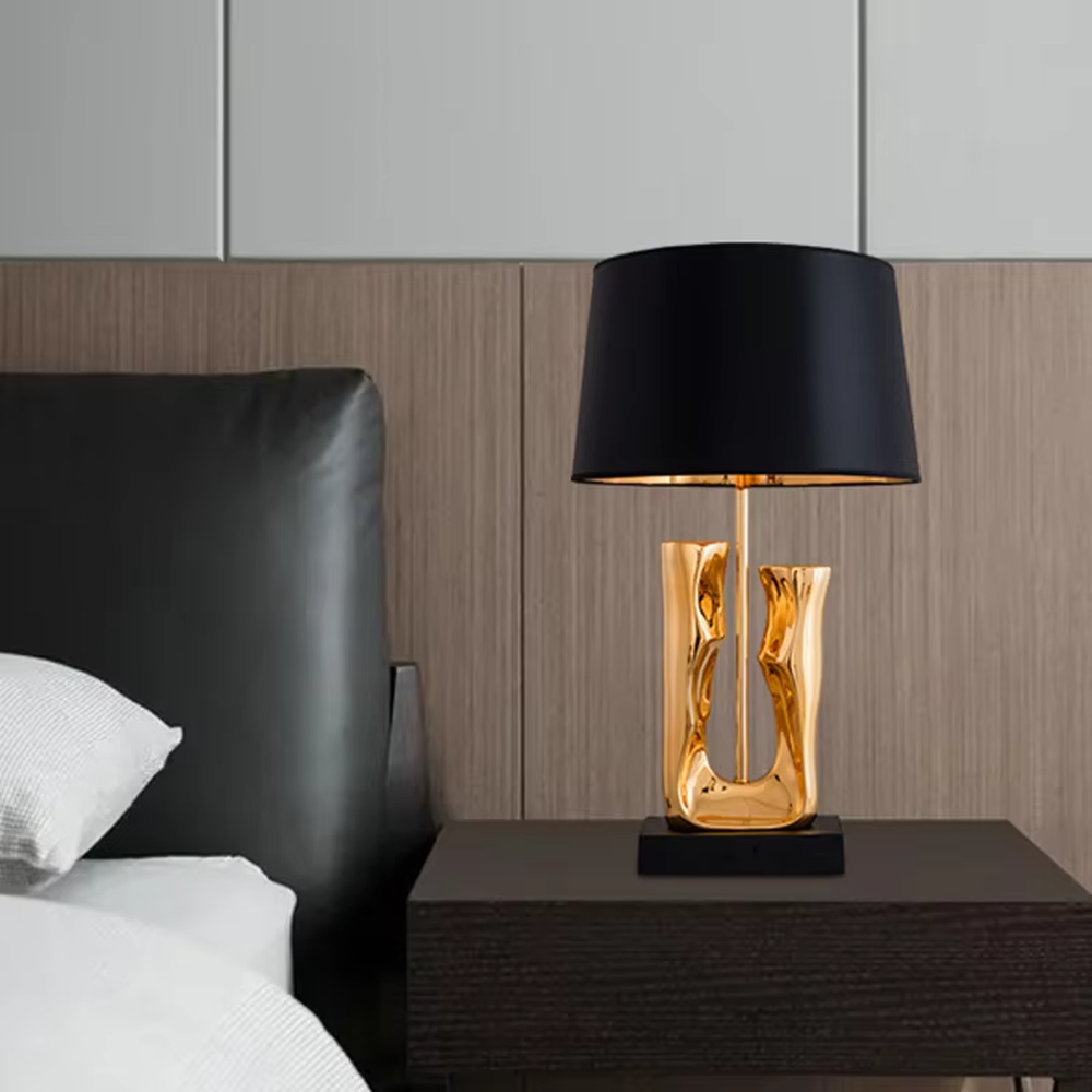 Modern art luxury black-gold sculpture base table lamp, golden streamlined sculpture base + black shade with gold lining + warm light effect, creating a high-end artistic luxury atmosphere.