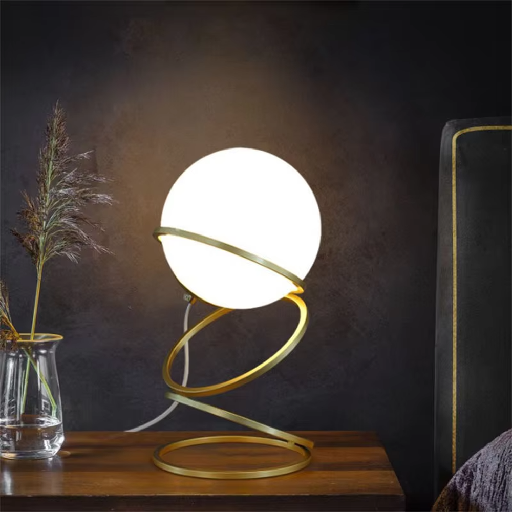 This is a light luxury spiral metal stand table lamp, with a gold spiral design paired with a white spherical frosted lampshade, featuring both decorative and lighting functions, ideal for modern indoor scenarios such as living room side tables and bedroom nightstands.
