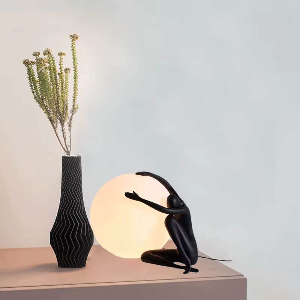 Artistic humanoid sculpture lifting spherical soft light table lamp (black sculpture + warm light ball shade), warm light effect, creating a creative artistic space atmosphere.