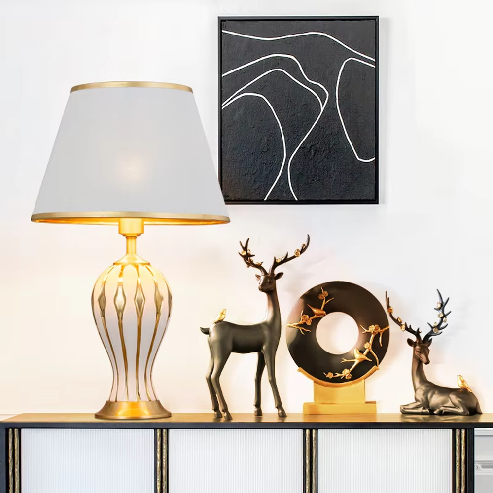 European-style light luxury ceramic table lamp, with a green-gold gradient wavy ceramic base, off-white pleated fabric lampshade and gold metal details, providing soft and warm light, designed to enhance the retro and elegant atmosphere of spaces, suitable for bedroom nightstands, living room side tables, European-style homes and hotel guest rooms, etc.