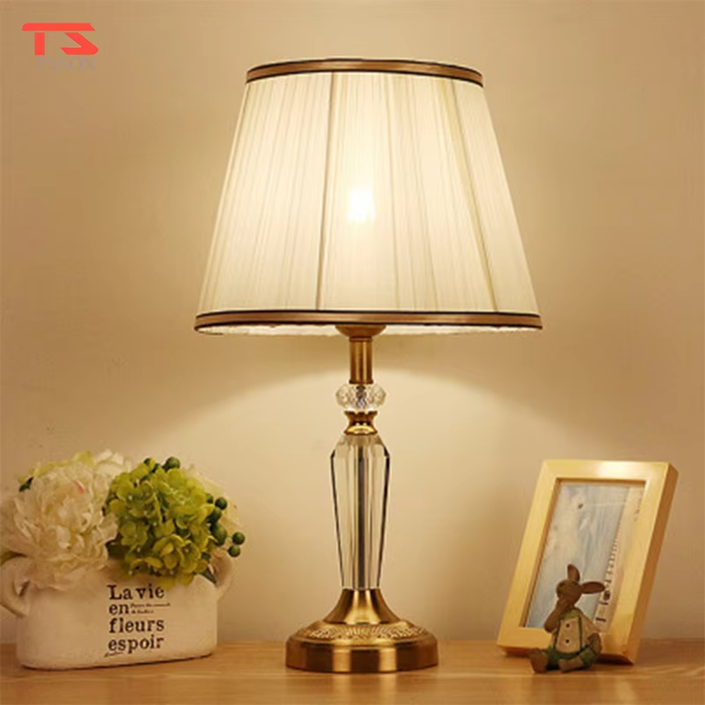Light luxury crystal fabric table lamp (pleated fabric lampshade + crystal lamp post + antique bronze metal base), warm light effect, creating an elegant and luxurious home atmosphere.