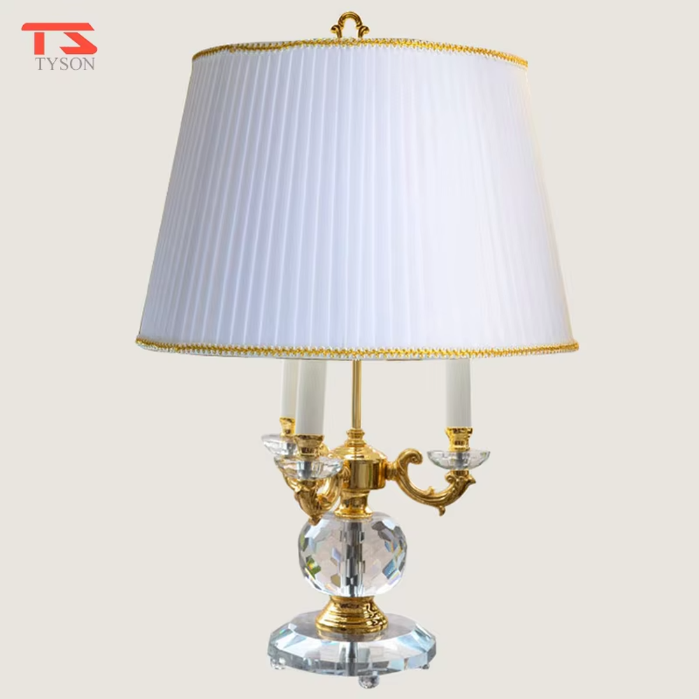 This European court-style table lamp features a carved lamp frame made of glossy gold metal, paired with a crystal ball base and a pleated fabric lampshade (trimmed with gold edging). It presents a luxurious and retro texture, with soft and warm light, serving both lighting and decorative purposes, suitable for European-style bedrooms, villa guest rooms and other spaces.