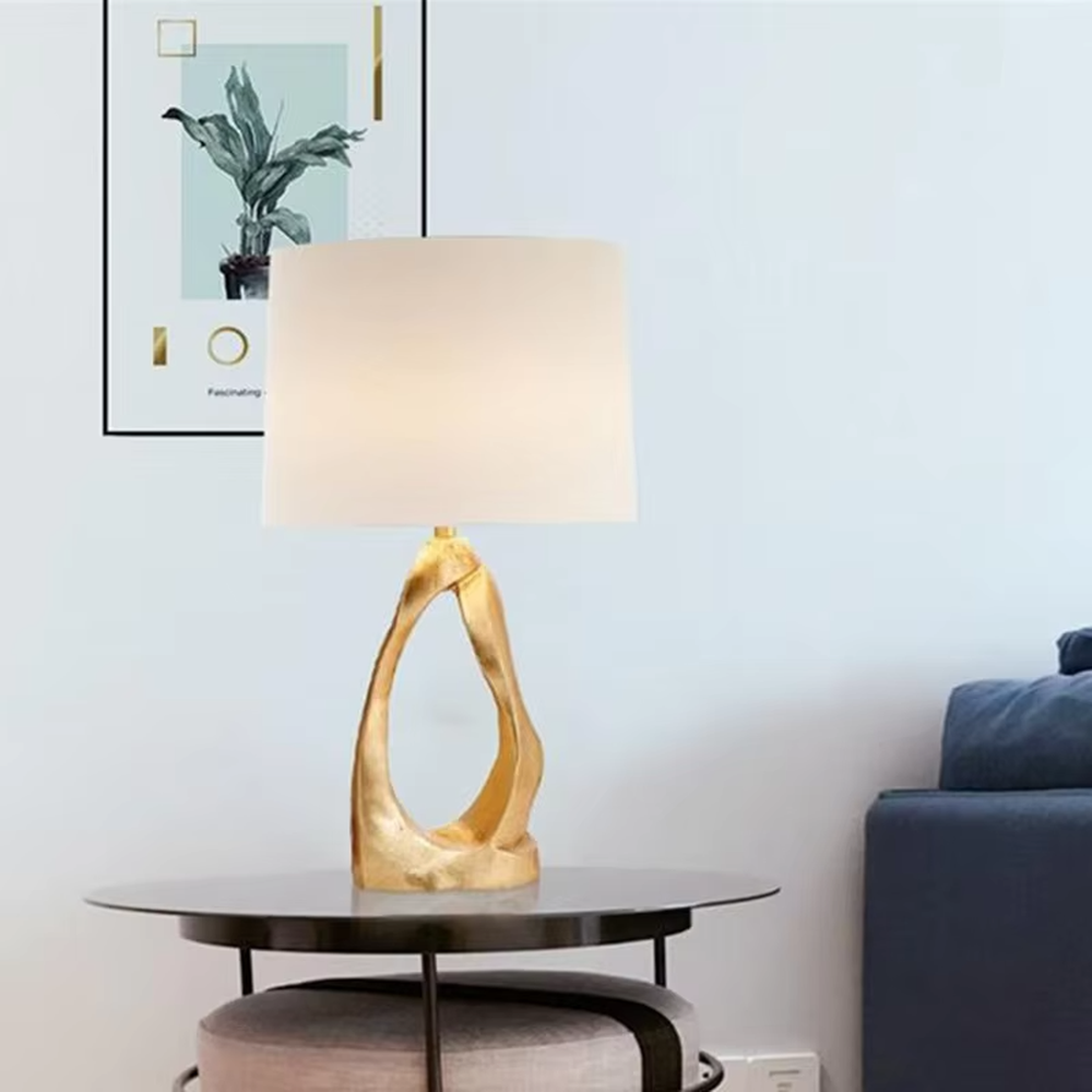 Art texture gold base table lamp (irregular gold base + fabric shade), warm light effect, creating an artistic and high-end light luxury home atmosphere.