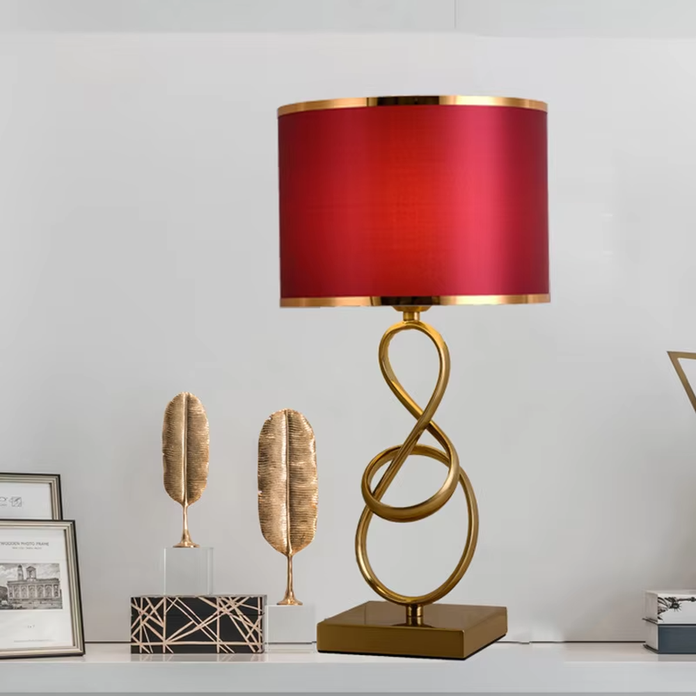 Modern light luxury twisted line metal table lamp, with a gold twisted line lamp pole paired with a beige fabric lampshade (with gold trim on the edge), a square gold base, emitting soft and warm light, combining decorativeness and practicality, suitable for lighting and decoration in spaces such as bedroom nightstands, living room side tables, and studies.