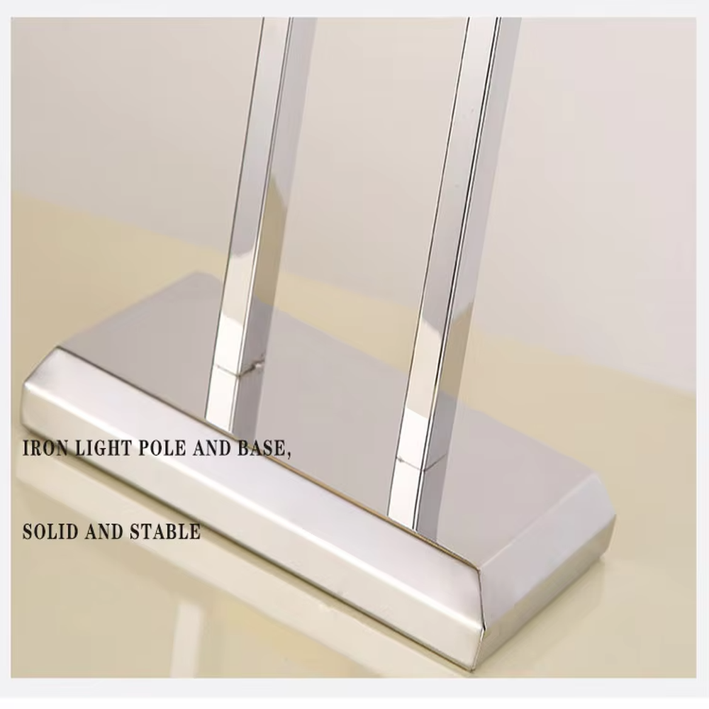 Modern minimalist table lamp with a chrome-plated metal frame and a rectangular off-white fabric lampshade, emitting soft and warm light. It is both decorative and practical, suitable for lighting and decoration in living rooms, bedrooms, studies and other spaces.