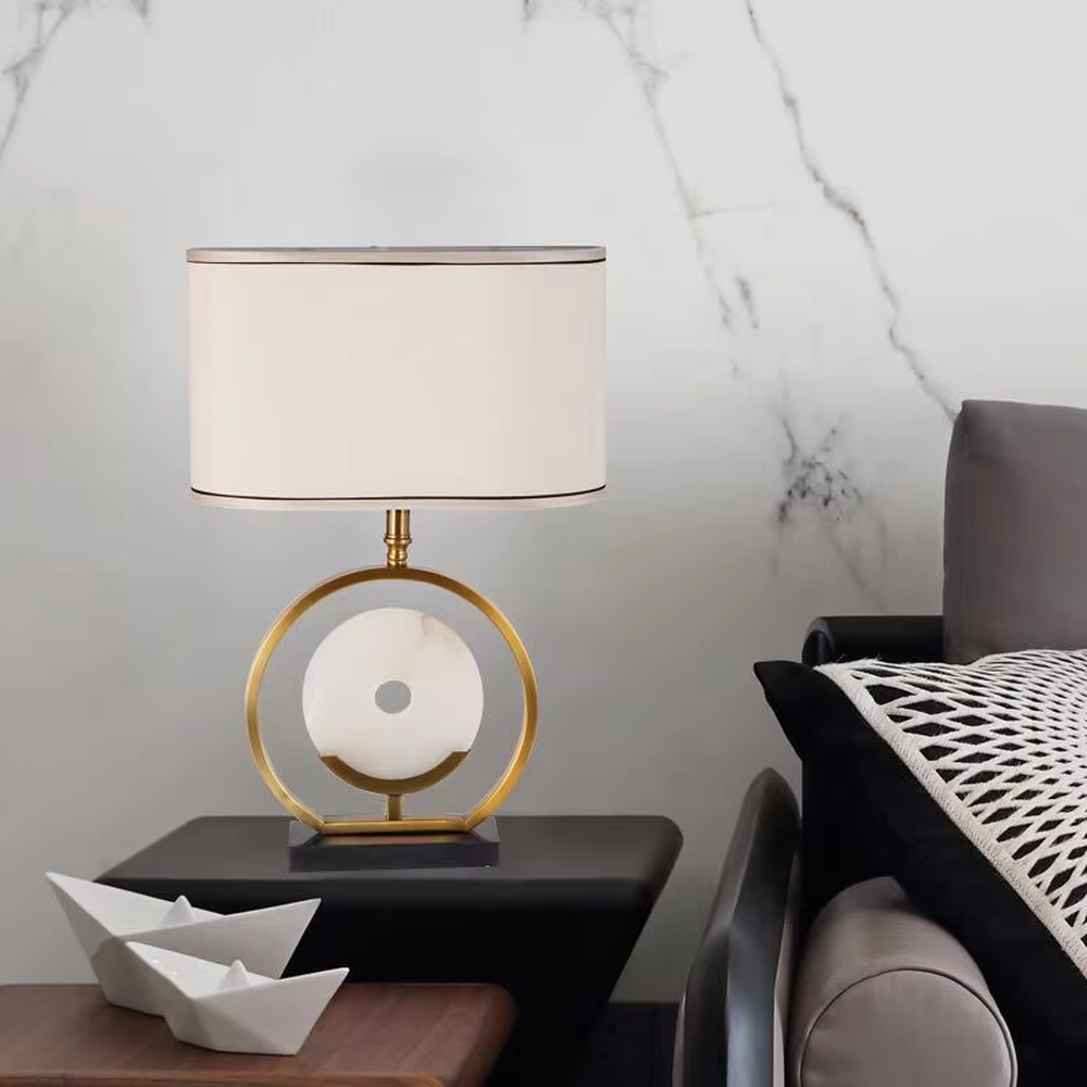 Modern light luxury gold ring white spherical base beige trimmed fabric shade table lamp, warm light effect, creating an elegant home atmosphere.