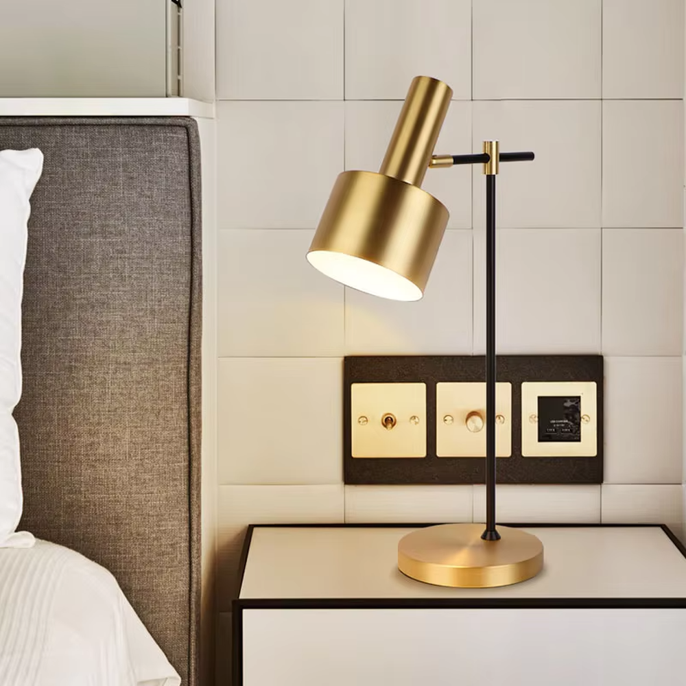 Modern light luxury black-gold adjustable metal table lamp, golden lampshade + black-gold stand + round golden base, angle-adjustable, soft warm light, creating a simple high-end office/home atmosphere.