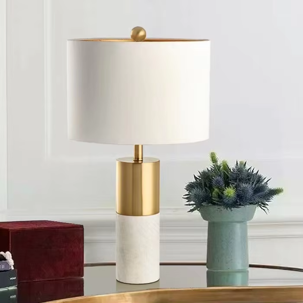 This light luxury modern table lamp features a lamp post made of black marble and gold metal, paired with an off-white fabric cylindrical lampshade. It has a calm and elegant shape, serves both lighting and decorative purposes, and is ideal for bedroom bedside tables, living room side tables, hotel guest rooms and light luxury commercial spaces.