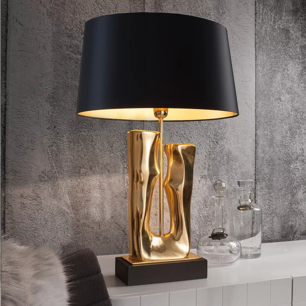 Modern art luxury black-gold sculpture base table lamp, golden streamlined sculpture base + black shade with gold lining + warm light effect, creating a high-end artistic luxury atmosphere.