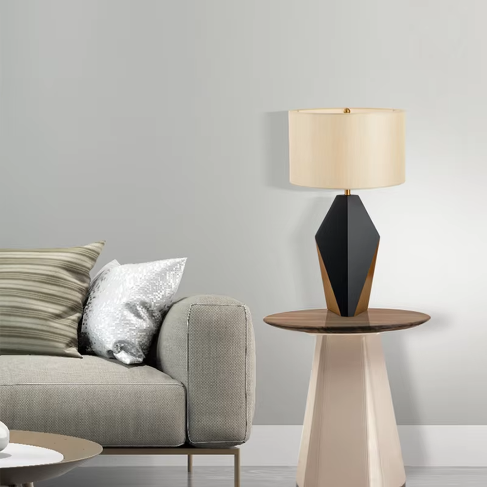 Light luxury black-gold geometric diamond base table lamp, black geometric diamond base + golden decorative details + beige fabric lampshade, soft warm light, creating a high-end light luxury bedroom atmosphere.