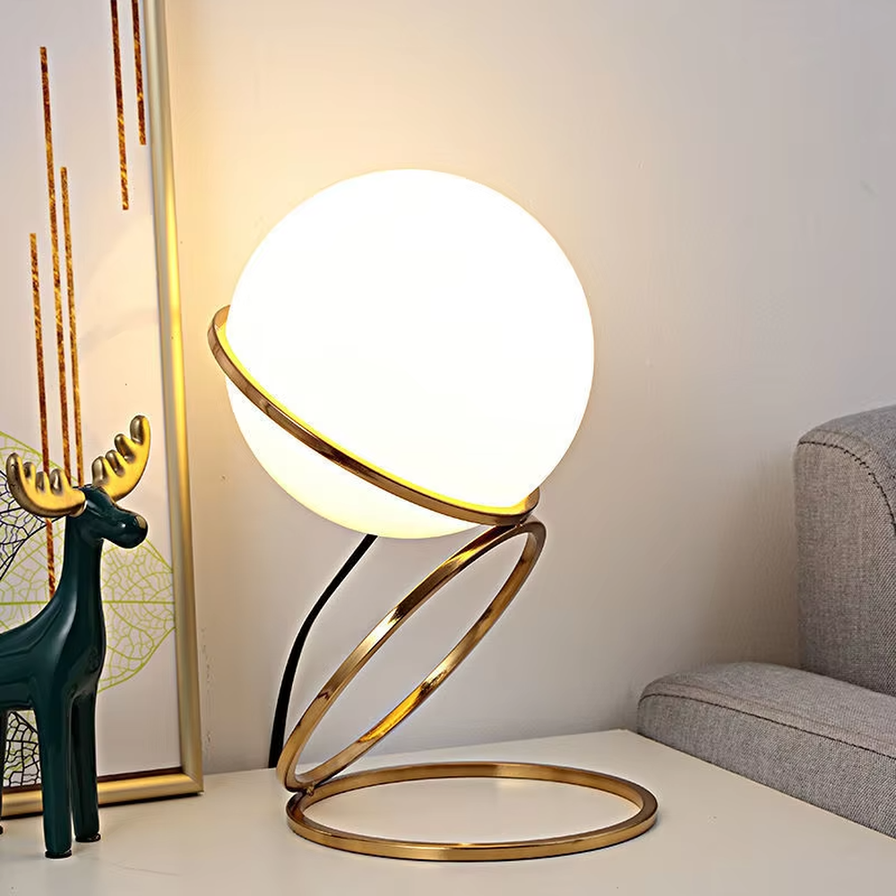 Modern planet orbit-shaped table lamp (white ball + gold ring stand), warm light effect, creating a sci-fi artistic minimalist space atmosphere.