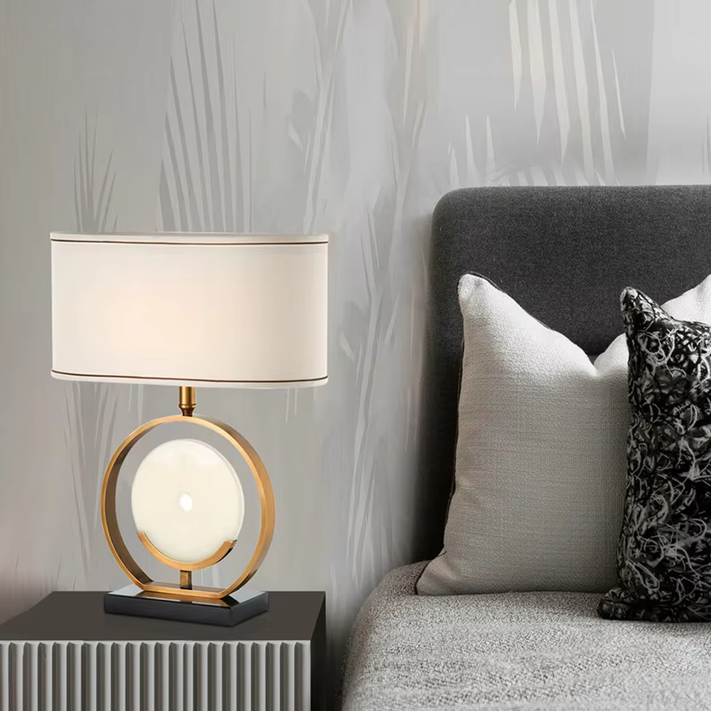 Modern light luxury gold ring white spherical base beige trimmed fabric shade table lamp, warm light effect, creating an elegant home atmosphere.
