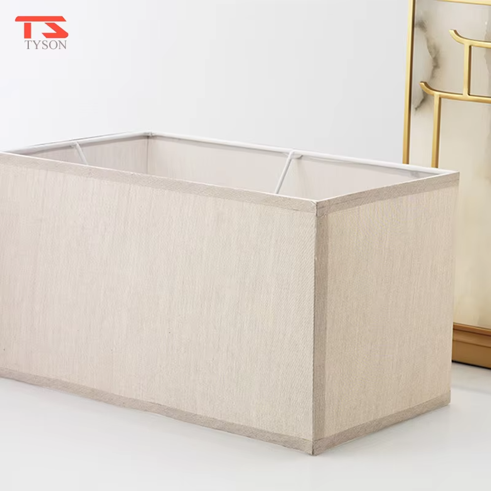 This is a new Chinese style table lamp, featuring a rectangular fabric lampshade paired with a geometric splicing base with Chinese architectural elements, which has both lighting and decorative functions, suitable for bedrooms, studies, tea rooms, new Chinese-style homes and hotel guest rooms and other spaces.