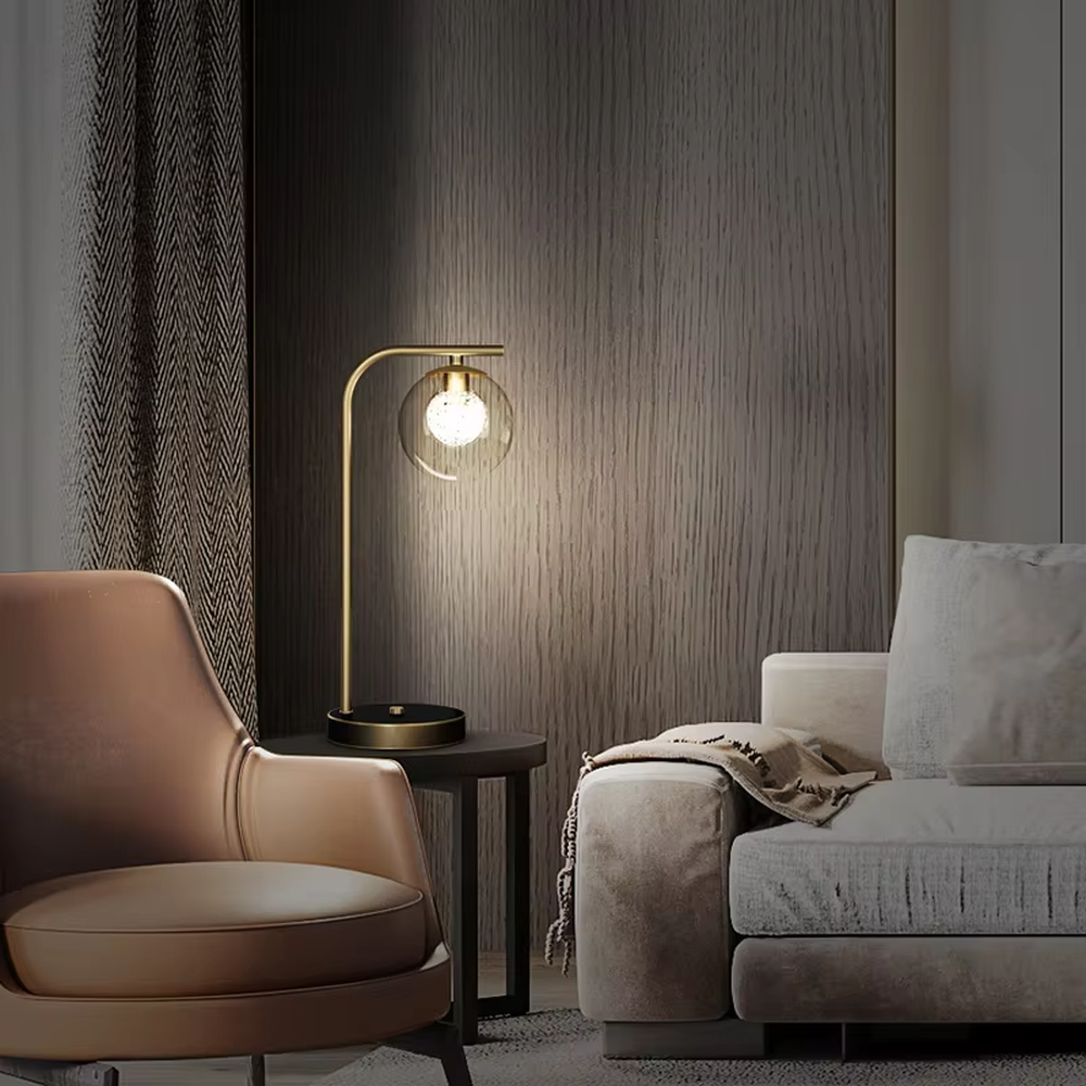 Modern light luxury golden curved pole transparent glass ball shade glitter bulb table lamp, warm light effect, creating a minimalist exquisite atmosphere.
