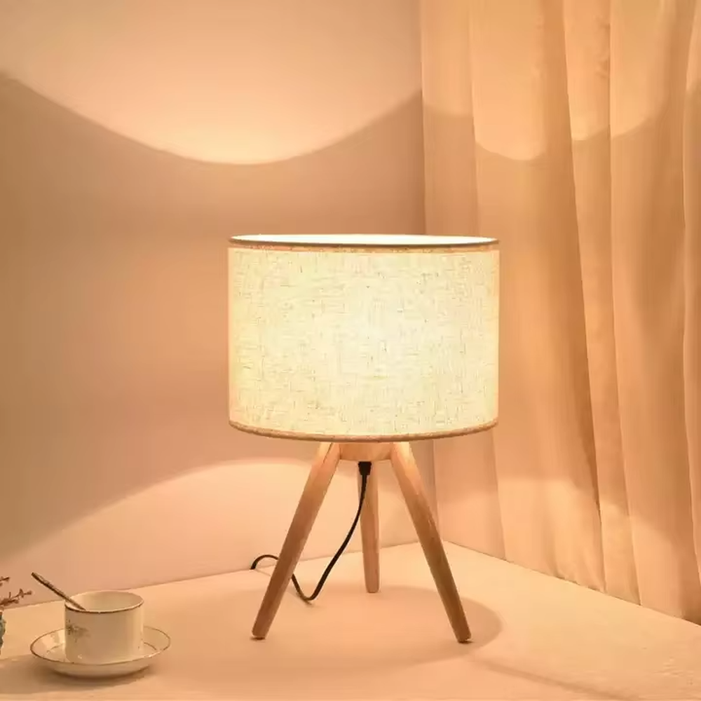 Wooden-style triangular stand table lamp (wooden tripod + linen lampshade), warm light effect, creating a natural and healing home atmosphere.
