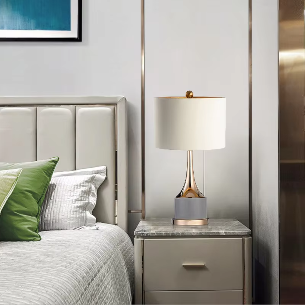 Light luxury gray-gold fabric lampshade metal base table lamp (gray fabric shade + gold pole + gray stone-pattern base), warm light effect, creating an exquisite and elegant atmosphere.