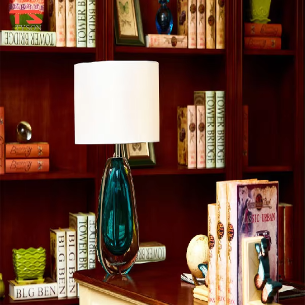 This is a fresh light luxury glass table lamp, with a royal blue fabric lampshade paired with a blue-green gradient hand-blown glass base, featuring both decorative and lighting functions, ideal for warm indoor scenarios such as bedroom nightstands and living room side tables.