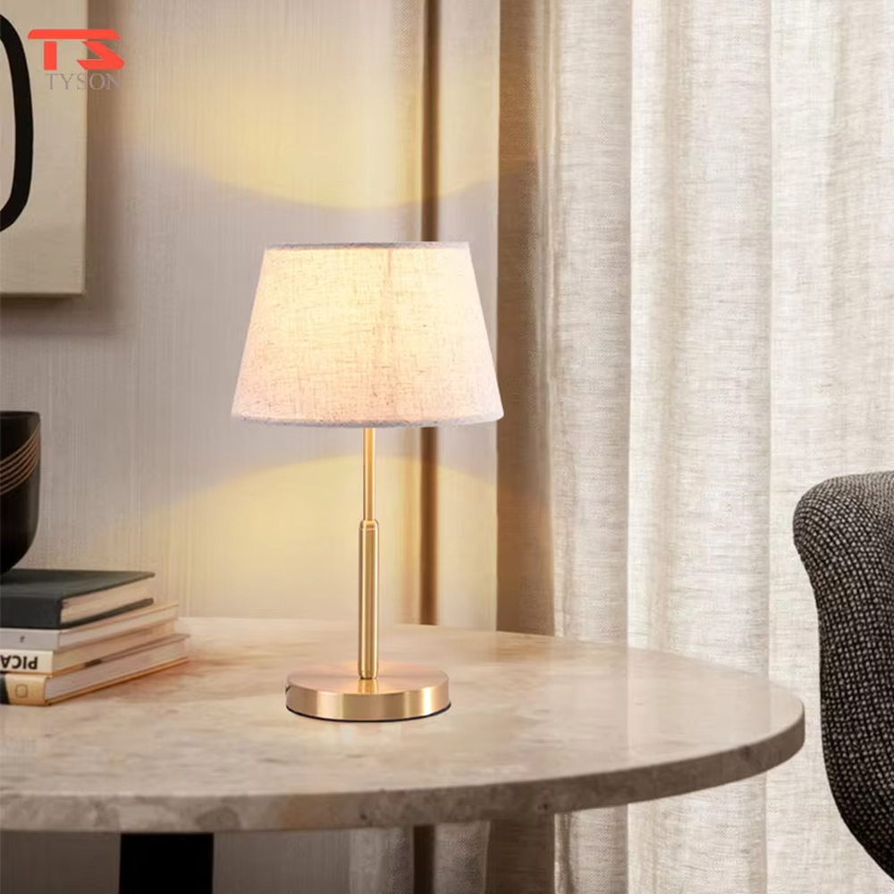 Modern light luxury golden metal pole linen texture fabric shade round base table lamp, warm light effect, creating an elegant minimalist home atmosphere.