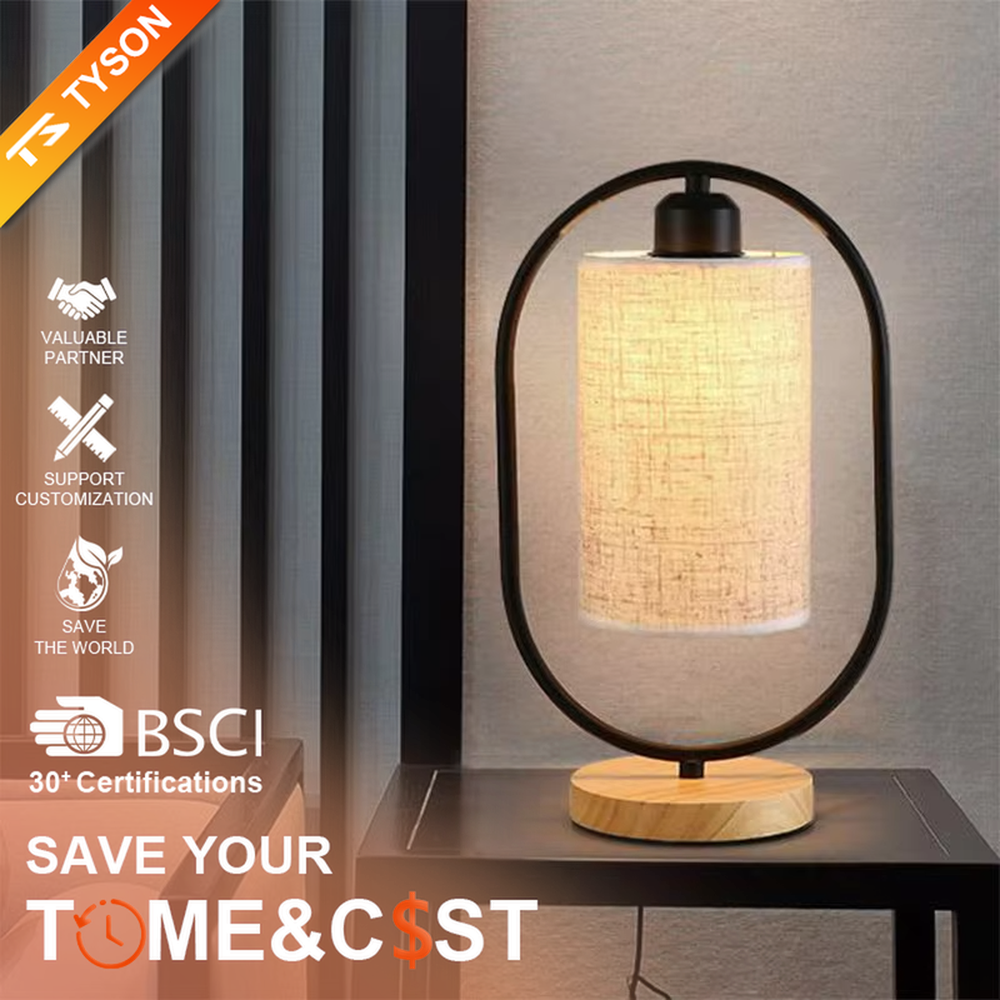 This is a modern minimalist oval frame table lamp, with a black metal oval stand paired with a beige linen lampshade and a solid wood base, featuring both decorative and lighting functions, ideal for warm indoor scenarios such as bedroom nightstands and living room side tables.
