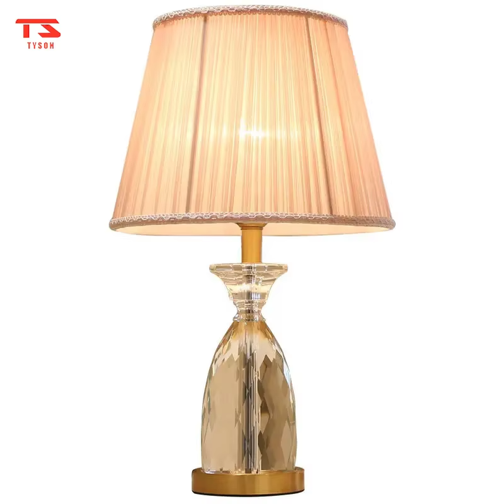 Light luxury crystal table lamp, with a diamond-cut crystal base, pink pleated fabric lampshade and gold metal details, providing soft and warm light, designed to enhance the elegant atmosphere of spaces, suitable for bedroom nightstands, living room side tables, princess rooms, etc.