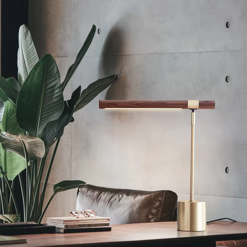 This is a modern minimalist style eye-protecting table lamp, featuring a walnut lamp head paired with a brass metal lamp pole and base. The linear lighting design is soft and non-glaring, serving both practical lighting and decorative purposes, suitable for study rooms, bedroom nightstands, light luxury office areas and other scenarios.