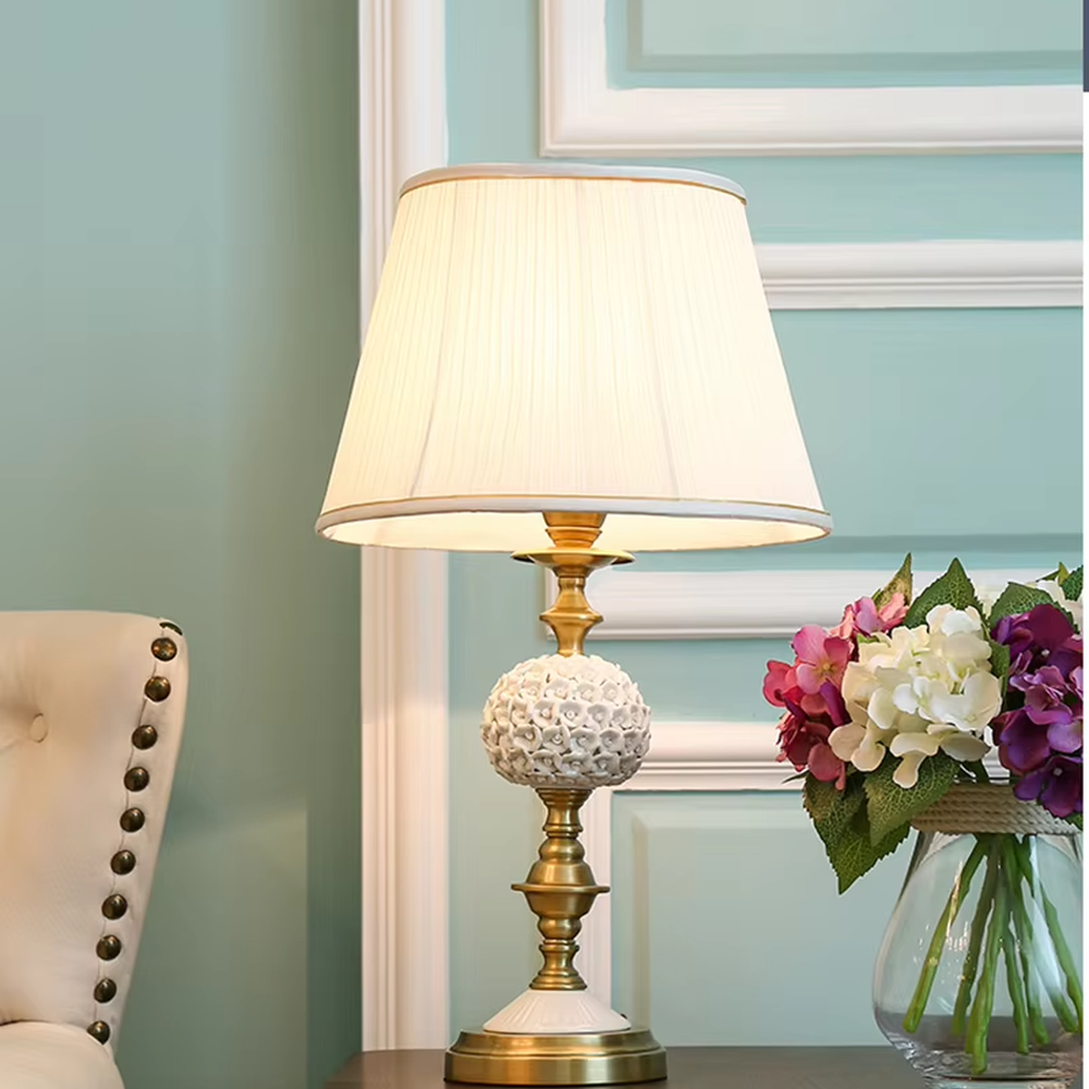 Vintage carved glass table lamp (brass stand + pleated fabric shade), warm light effect, creating an elegant vintage light luxury home atmosphere.