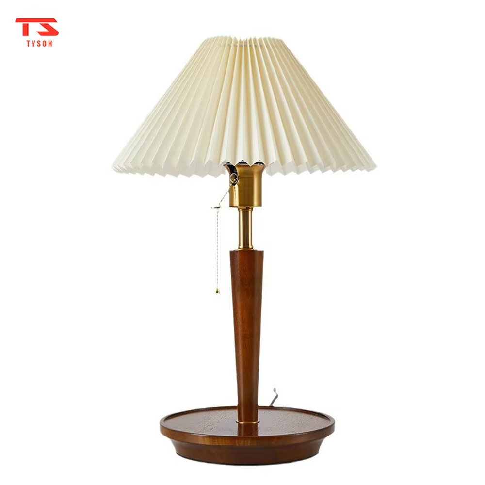 Vintage Nordic pleated fabric table lamp, with an off-white pleated fabric lampshade paired with a dark brown wood and gold metal spliced lamp pole, featuring a pull-cord switch, emitting soft and warm light, combining decorativeness and practicality, suitable for lighting and decoration in spaces such as bedroom nightstands, living room side tables, and B&B guest rooms.