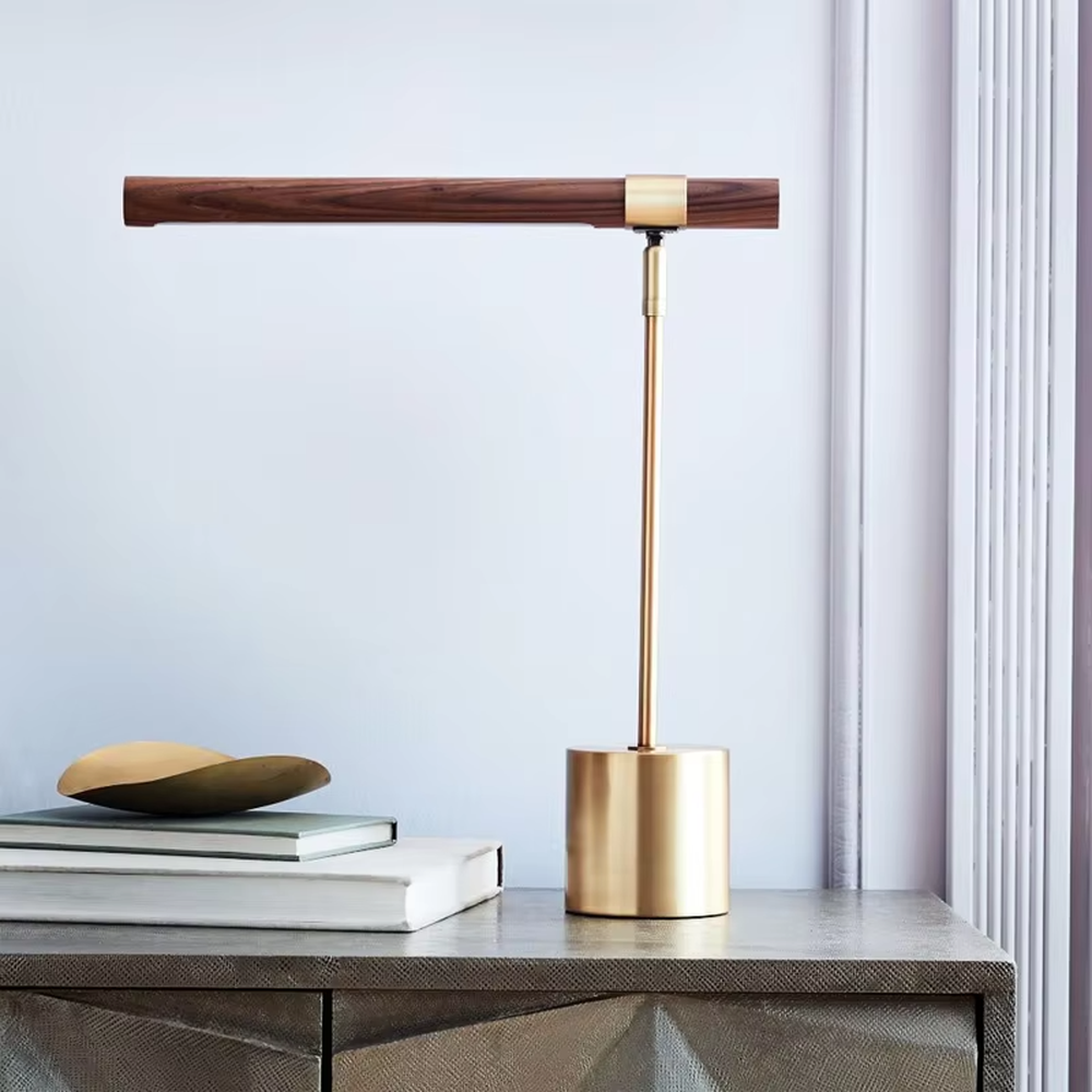This is a modern minimalist style eye-protecting table lamp, featuring a walnut lamp head paired with a brass metal lamp pole and base. The linear lighting design is soft and non-glaring, serving both practical lighting and decorative purposes, suitable for study rooms, bedroom nightstands, light luxury office areas and other scenarios.