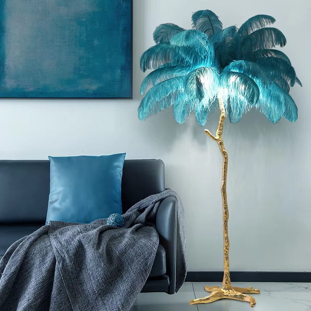 This is a luxury artistic floor lamp with a golden branch - shaped stand and a pink ostrich feather lampshade, featuring a romantic and luxurious design that shows elegant texture under warm light. It is used for space lighting and artistic decoration, combining practicality and aesthetics. It is suitable for modern luxury home living rooms, bedrooms, high - end hotel leisure areas, wedding photography scenes and other places.