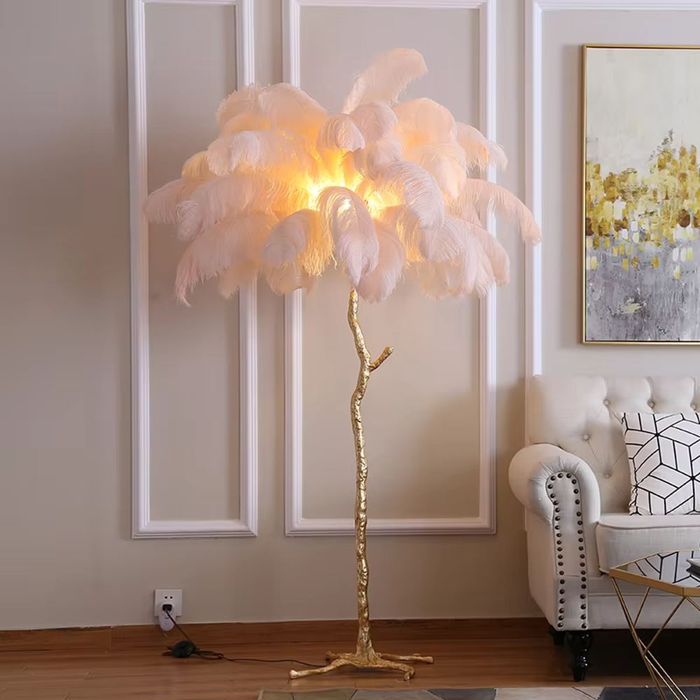 This is a luxury artistic floor lamp with a golden branch - shaped stand and a pink ostrich feather lampshade, featuring a romantic and luxurious design that shows elegant texture under warm light. It is used for space lighting and artistic decoration, combining practicality and aesthetics. It is suitable for modern luxury home living rooms, bedrooms, high - end hotel leisure areas, wedding photography scenes and other places.