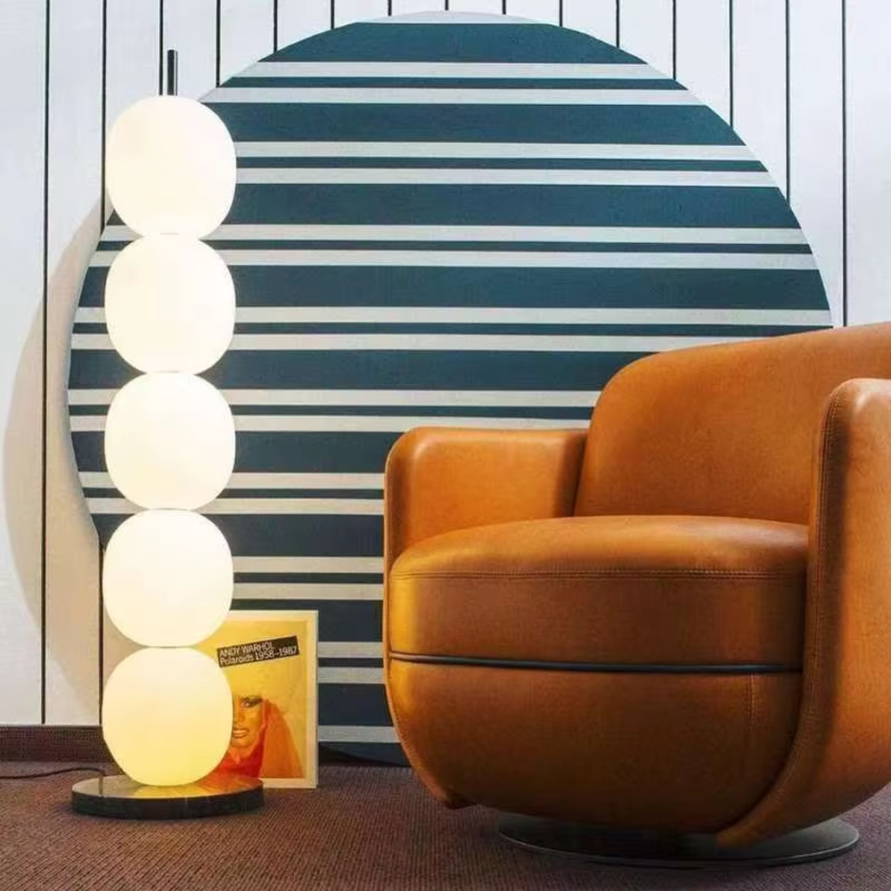 This is a modern minimalist multi-layer spherical glass floor lamp, with a black base and multiple white spherical glass lampshades stacked vertically. It features a minimalist and grand design, with soft and uniform lighting. It is used for space ambient lighting and decoration, creating a modern minimalist and warm atmosphere. Suitable for modern minimalist living rooms, Nordic-style homes, art studios and other places.