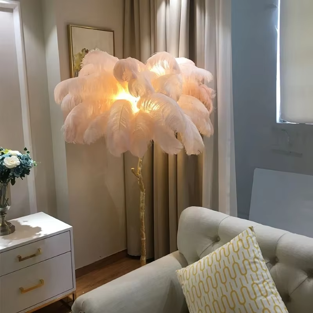 This is a light luxury artistic feather-shaped floor lamp, with a golden branch-shaped metal bracket and numerous pink ostrich feathers. It features a romantic and luxurious design, with warm and soft lighting. It is used for space ambient lighting and decoration, creating a romantic artistic atmosphere. Suitable for light luxury-style bedrooms, internet-famous check-in shops, art homestays and other places.