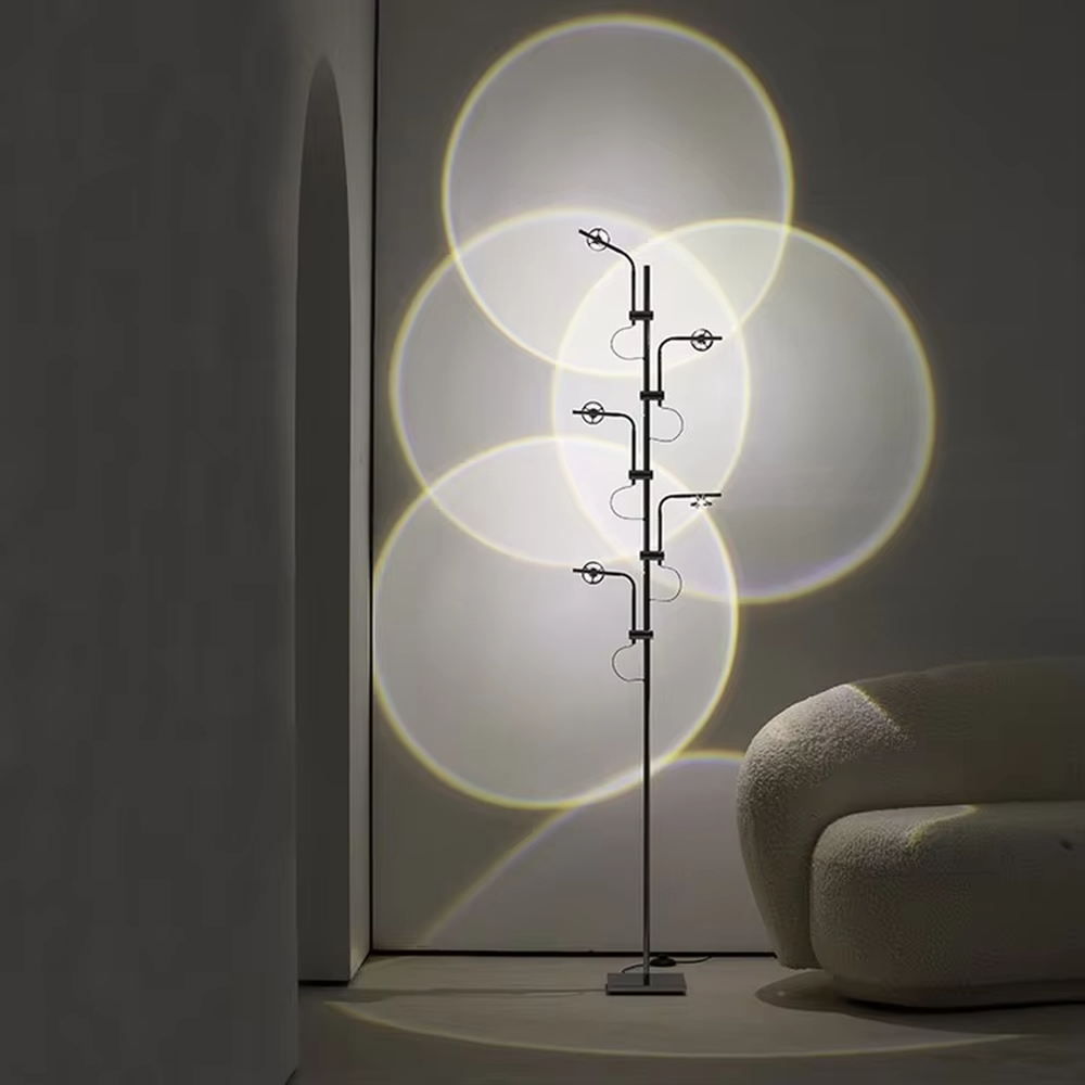 This is a modern artistic multi-circular light and shadow floor lamp, with a metal branch-like structure and multiple circular light-emitting panels. The light projects circular light and shadow with yellow edges, featuring a strong sense of modern art and light-shadow hierarchy. It is used for space lighting and decoration, creating a warm and artistic atmosphere. Suitable for modern bedrooms, artistic living rooms, designer studios and other places.
