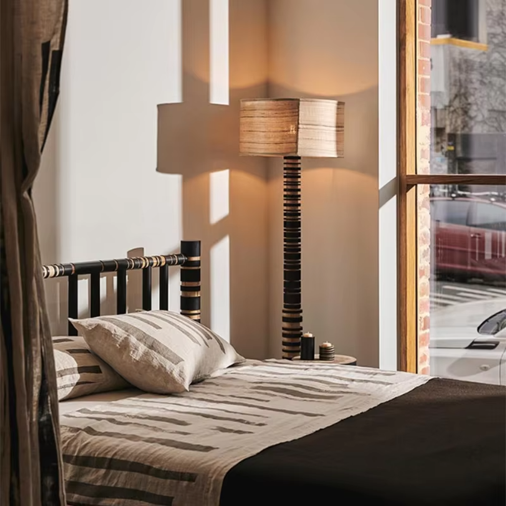 This is a natural retro-style wooden floor lamp, with a stand of alternating black and natural wood stripes and a wooden cylindrical lampshade, featuring a natural retro design and unique texture. It is used for space lighting and decoration, creating a natural and warm retro atmosphere. It is suitable for natural-style home living rooms, homestay leisure areas, art studios and other places.