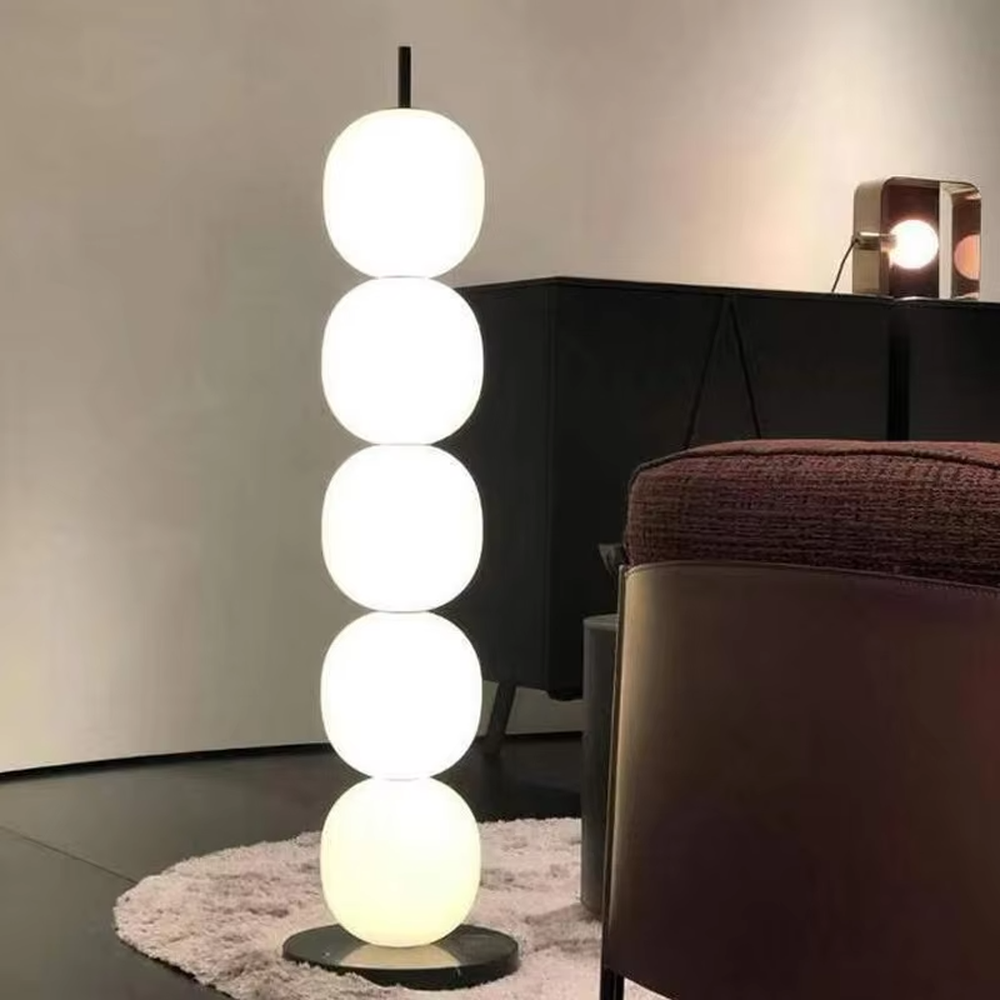 This is a modern minimalist multi-layer spherical glass floor lamp, with a black base and multiple white spherical glass lampshades stacked vertically. It features a minimalist and grand design, with soft and uniform lighting. It is used for space ambient lighting and decoration, creating a modern minimalist and warm atmosphere. Suitable for modern minimalist living rooms, Nordic-style homes, art studios and other places.