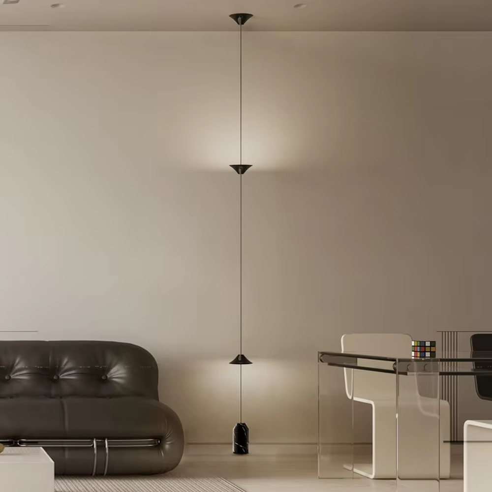 This is a modern artistic golden conical long-string chandelier, with multiple golden conical lamp bodies connected in series and a black marble base, featuring a minimalist artistic design and modern style. It is used for space lighting and decoration, creating an artistic and modern atmosphere. Suitable for modern art home stairwells, high-ceilinged living rooms, designer studios and other places.