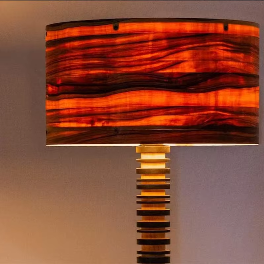 This is a natural retro-style wooden floor lamp, with a stand of alternating black and natural wood stripes and a wooden cylindrical lampshade, featuring a natural retro design and unique texture. It is used for space lighting and decoration, creating a natural and warm retro atmosphere. It is suitable for natural-style home living rooms, homestay leisure areas, art studios and other places.