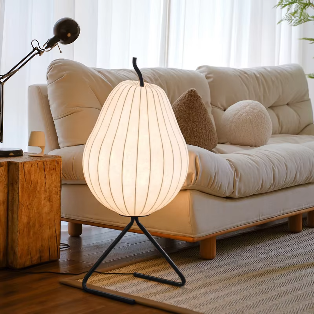 This is a childlike artistic pear-shaped floor lamp, made of paper-like material to create a pear shape, paired with a black metal stand. It features a childlike and natural design, with warm and soft lighting. It is used for space ambient lighting and decoration, creating a childlike and natural atmosphere. Suitable for Nordic-style homes, literary homestays, children's rooms and other places.