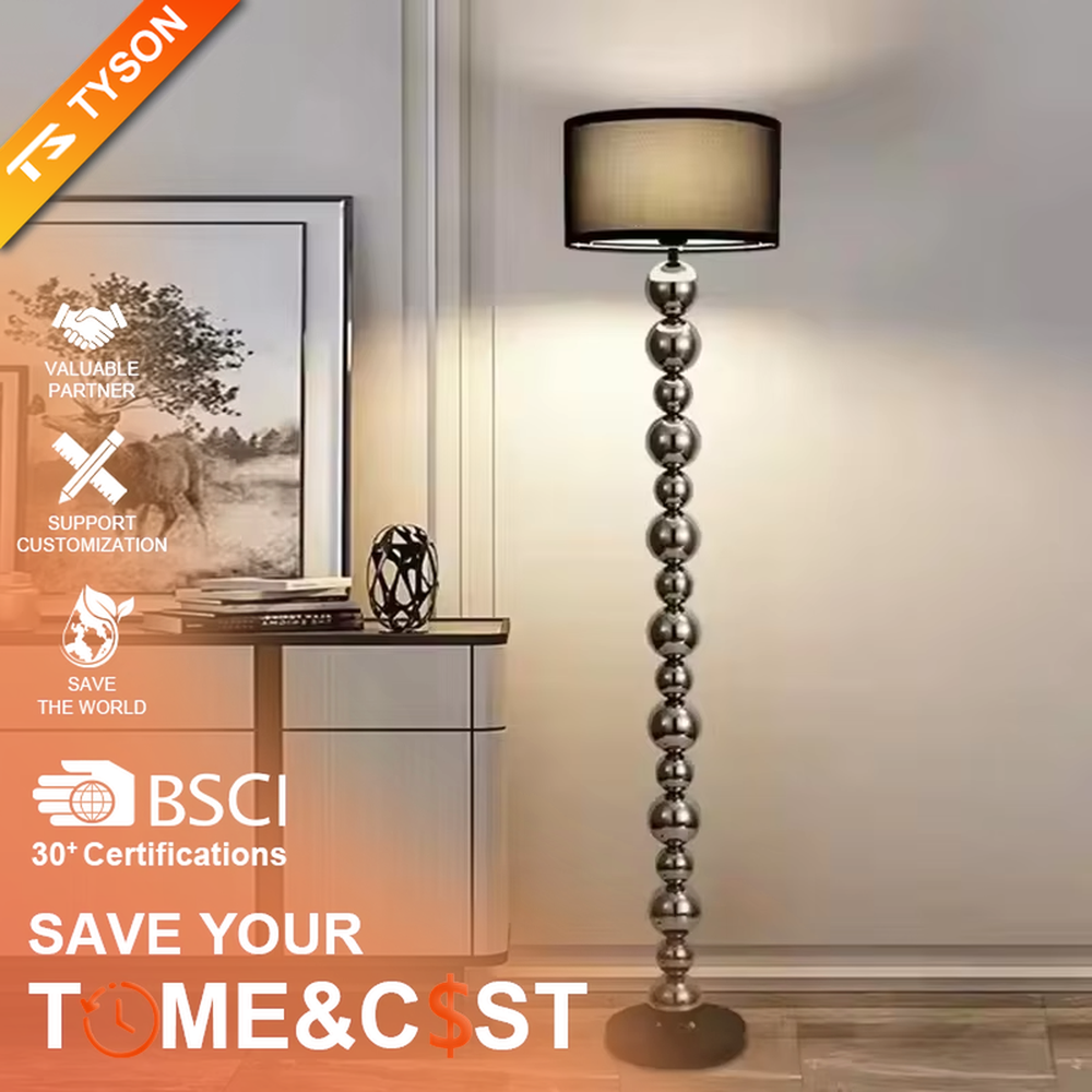 This is a light luxury exquisite silver metal ball column floor lamp, with silver metal balls layered to form a column, paired with a beige fabric round lampshade. It features a light luxury and exquisite design, with soft lighting. It is used for space ambient lighting and decoration, creating a light luxury elegant atmosphere. Suitable for light luxury-style living rooms, modern minimalist bedrooms, high-end hotel guest rooms and other places.