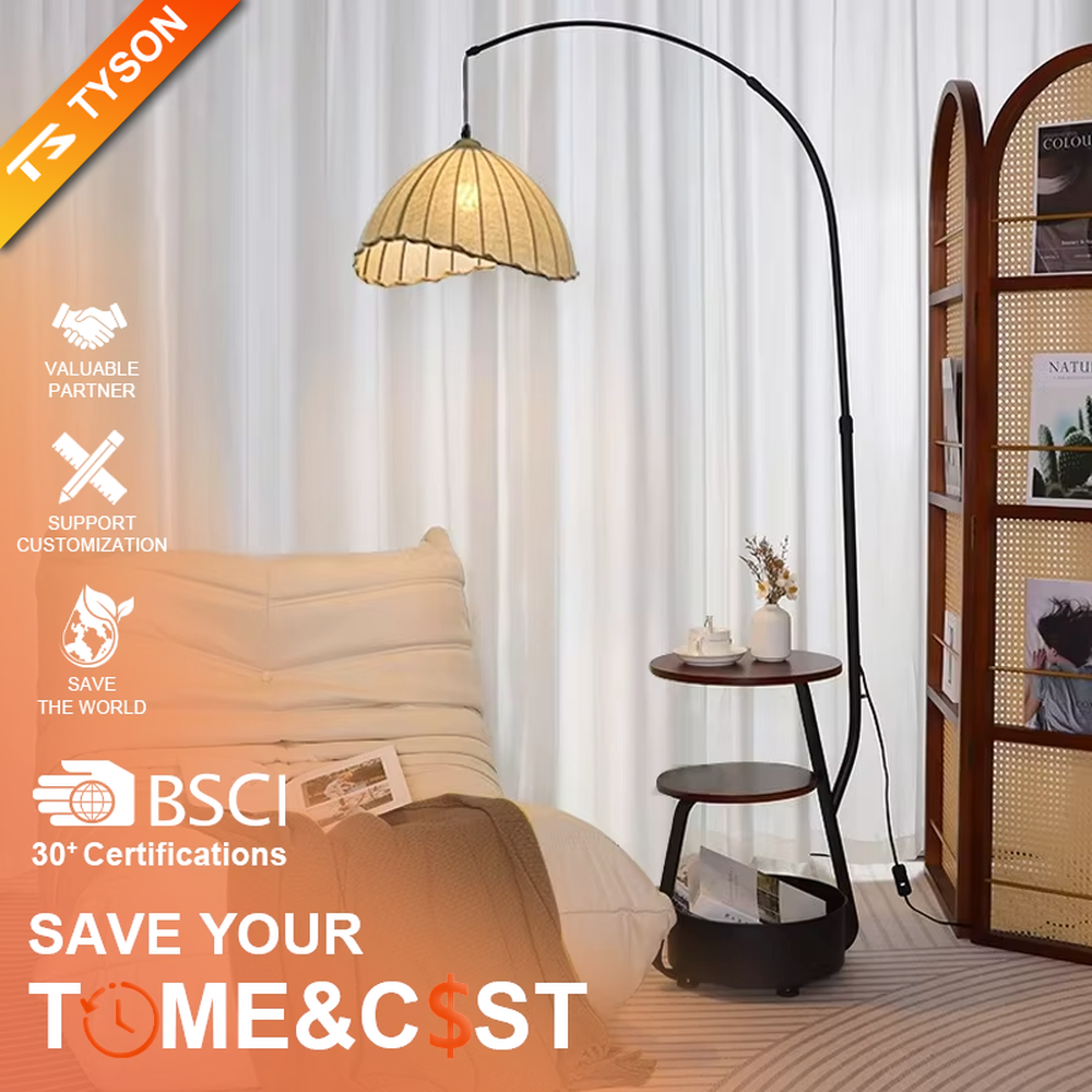 This is a modern multi-functional arc floor lamp with a black metal arc pole, a shell-shaped fabric lampshade, and integrated multi-layer storage shelves, featuring a minimalist and practical design. It is used for space lighting, storage, and decoration, creating a warm and practical atmosphere. It is suitable for modern home living rooms, small-sized residences, leisure reading areas and other places.